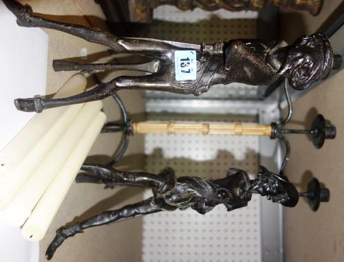 A pair of figural metal candlesticks and a metal and bamboo candlestick, (3).
