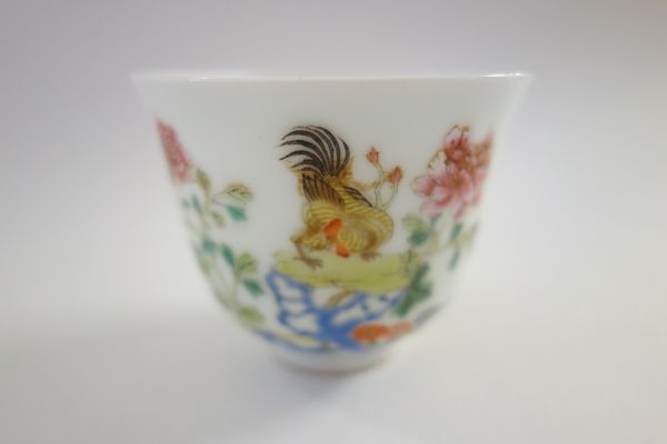 A Chinese famille-rose teabowl, blue Jiaqing sealmark but later, painted with chickens amongst flowering shrubs and blue pierced rocks, 5cm.high.
