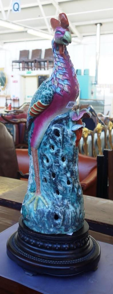 A large Chinese famille-rose figure of a pheasant, early 20th century, the colourful bird perched on a pierced rockwork base, (a.f), 61cm. high, match
