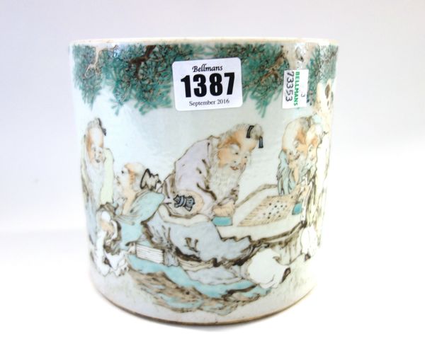 A Chinese porcelain cylindrical brush pot, 20th century, painted with sages at leisure beneath a pine tree, the reverse with calligraphy, 15cm. high.