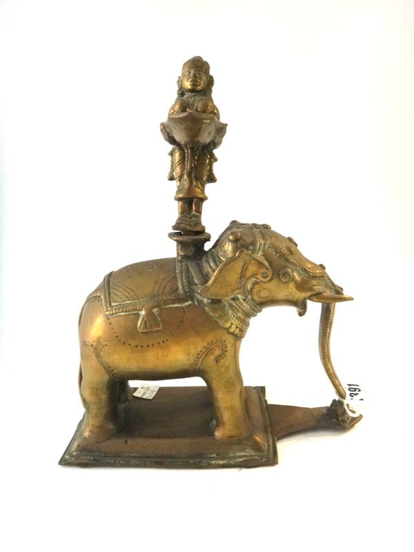 An Indian bronze oil lamp (dipa), late  19th century, in the form of a girl standing on the back of an elephant holding a pan, 26.5cm. high, made in t