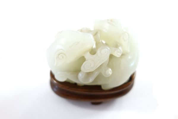 A Chinese white jade group of two cats, Qing Dynasty, 18th/19th century, each holding a sprig of lingzhi  in its mouth, 5cm.length, later wood stand.