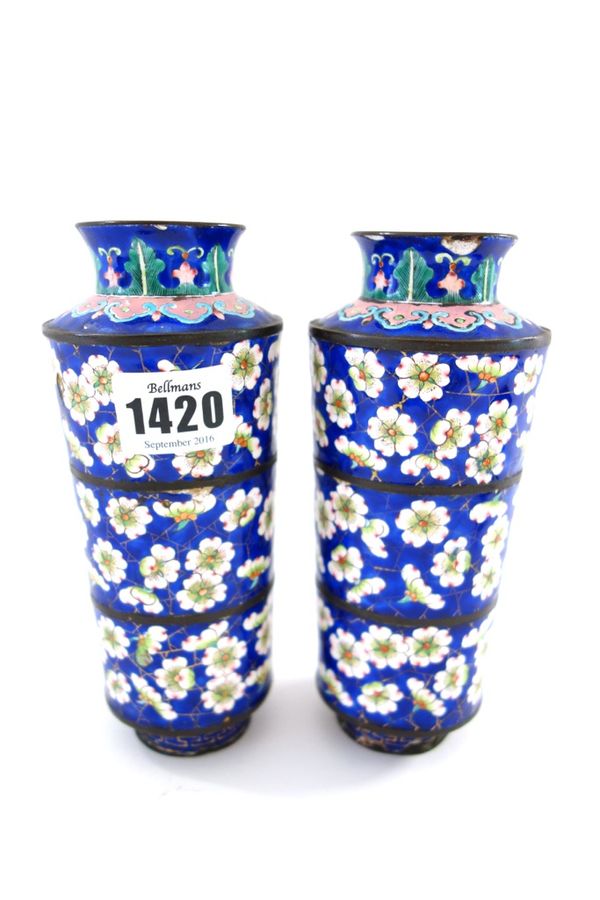 A pair of Canton enamel vases, early 19th century, of tapered cylindrical form, decorated with prunus against a blue `cracked-ice' ground, (one a.f).