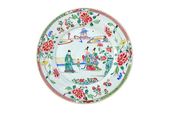 A Chinese famille-rose charger, Yongzheng, painted with a man holding a chime and standing with two ladies in a garden, the border painted with sprays