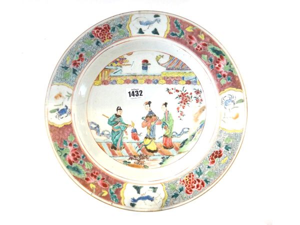 A Chinese famille-rose dish, Yongzheng, painted in the centre with a man holding a chime next to two ladies in a garden, the diaper panelled border en