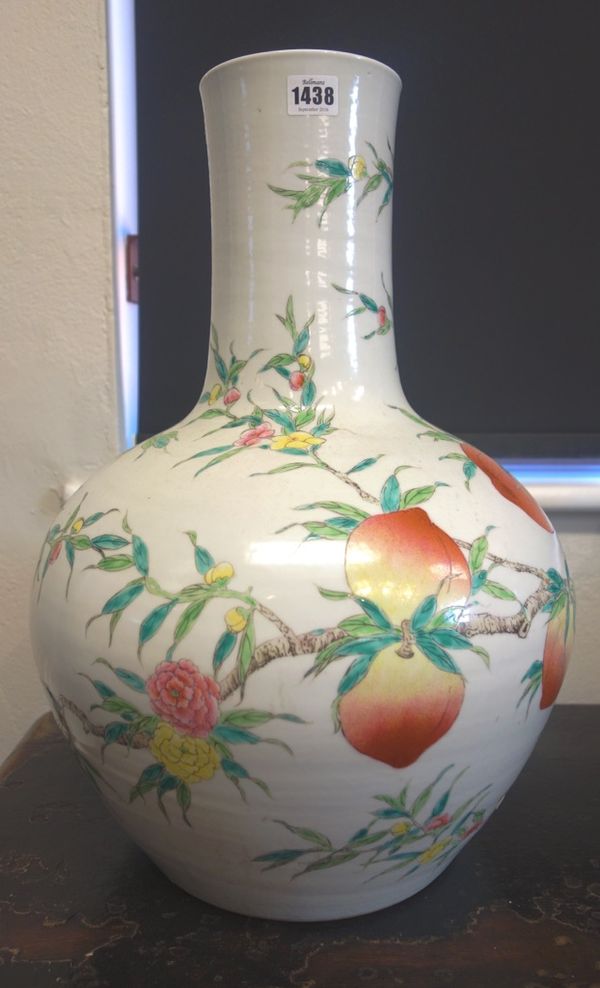 A large pair of Chinese famille-rose bottle vases, 20th century, each painted with branches of peaches and flowers, 54cm. high