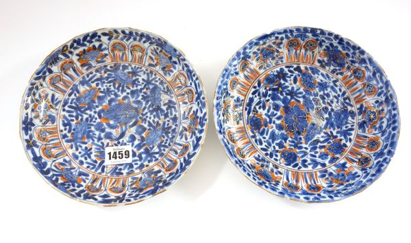 A pair of Chinese porcelain plates, Kangxi, painted in underglaze-blue and enamelled in iron-red and gilding with flowers, (a.f)21.5cm.diameter.
