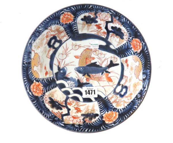 A Japanese Imari dish, Edo period, late 17th/early 18th century, painted in the centre with three carp, the border reserved with panels enclosing flow