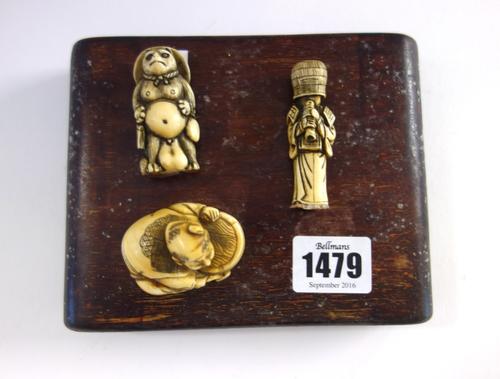 Three Japanese ivory netsuke, 19th/20th century, comprising; a man crouching over a barrel, 3.5cm.high; a standing figure playing a pipe, 5.5cm; and a