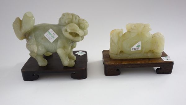 Four Chinese jade groups, 20th century, comprising; a carving of a man standing with a basket, 12cm. high; a Buddhist lion, 13cm. wide; a bird on a ro