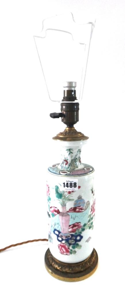 A Chinese famille-rose cylindrical vase, late 19th century, painted with vases and flowers, 25.5cm. high, adapted as a lamp with gilt-metal mounts; al