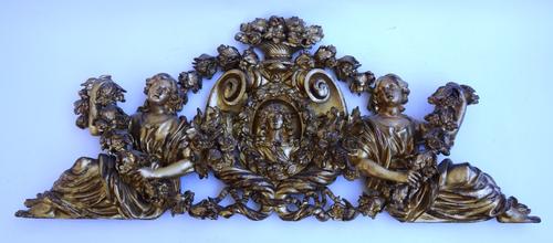 A 19th century carved gilt over door with opposing sea scrolls centred by a 17th century bust flanked by robed maidens all amongst flowering cornucopi