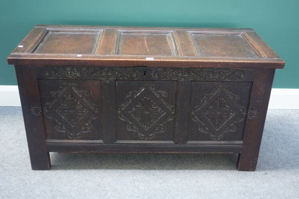 A late 17th century oak coffer, with triple panel lid and carved triple panel front, on stile feet, 120cm wide.