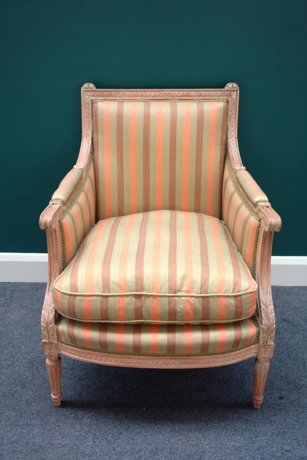 A Louis XVI style limed beech framed bergère, with semi-padded arms and bow seat, on tapering fluted supports.