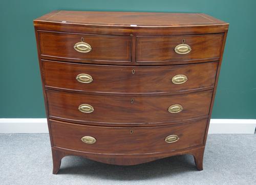 An early 19th century mahogany and inlaid bowfront chest of two short and three long graduated drawers, on splayed bracket feet, 107cm wide.