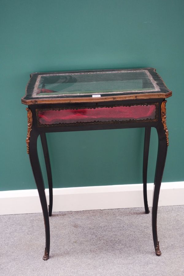 A late 19th century gilt metal mounted ebonised bijouterie table of serpentine outline on cabriole supports, 60cm wide.