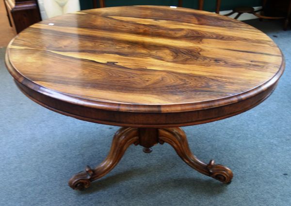 An early Victorian rosewood breakfast table, with a circular snap top on baluster octagonal column and three scroll supports, 121cm wide.