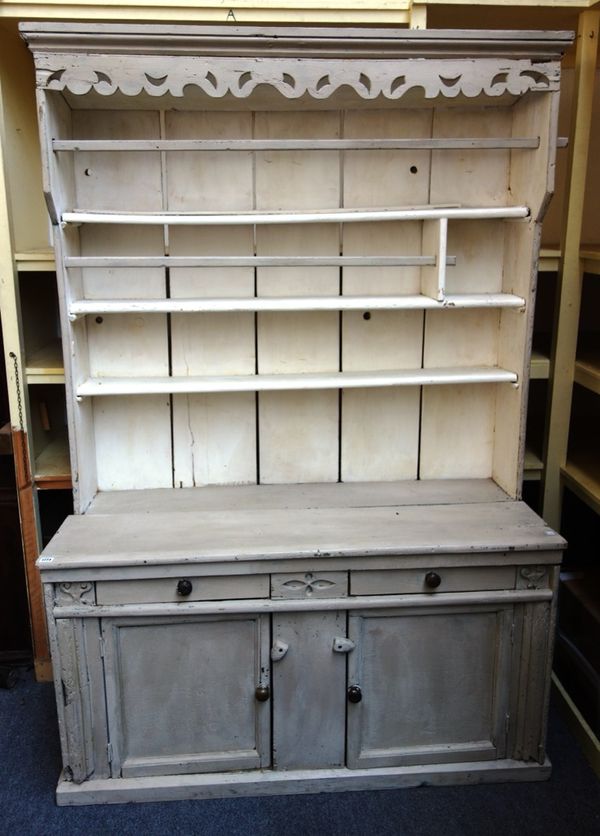 A 19th century and later white painted Irish pine dresser, the enlarged three tier plate rack over two short drawers and a pair of cupboards, 136cm wi