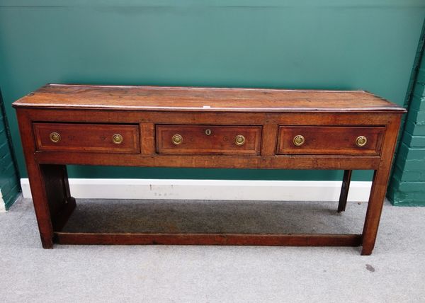 A George III oak dresser base, with three frieze drawers and enclosed panel sides, united by lower front stretcher, 182cm wide.