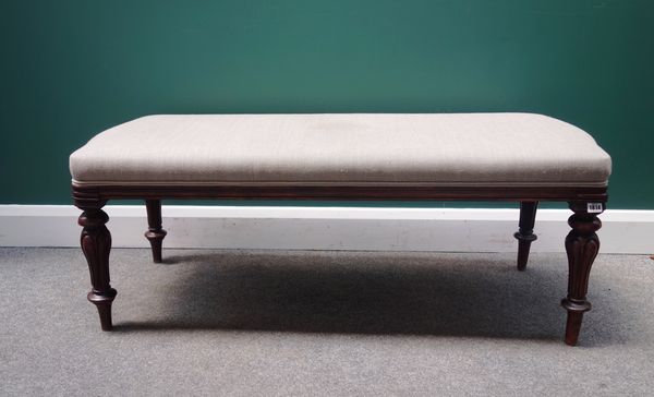 A mahogany framed rectangular footstool, with serpentine short ends on carved and turned supports, 126cm wide.