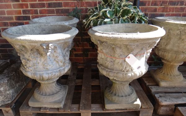 A set of eleven reconstituted stone garden urns, with semi-fluted bodies and spiral fluted socle, 58cm wide x 65cm high, (11).