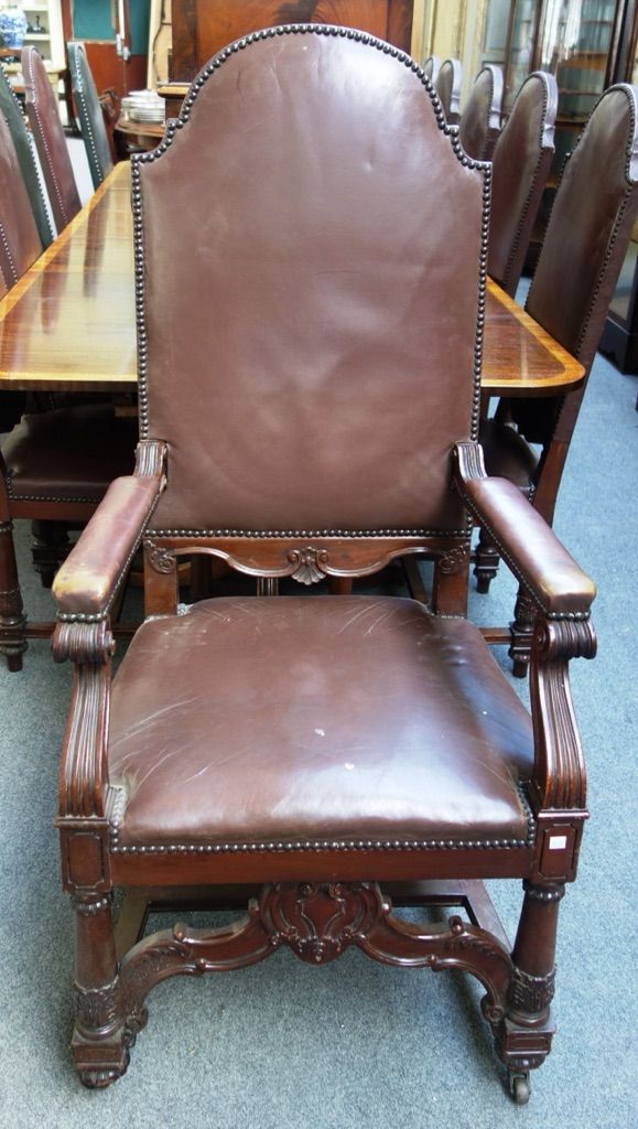 A set of twelve late 19th century carved mahogany framed dining chairs, each with studded leather upholstered high arch back, on turned supports, unit