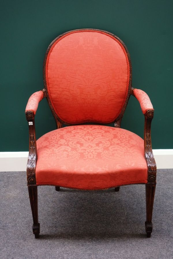 A George III stained and carved beech open armchair, with serpentine seat on channelled tapering supports.