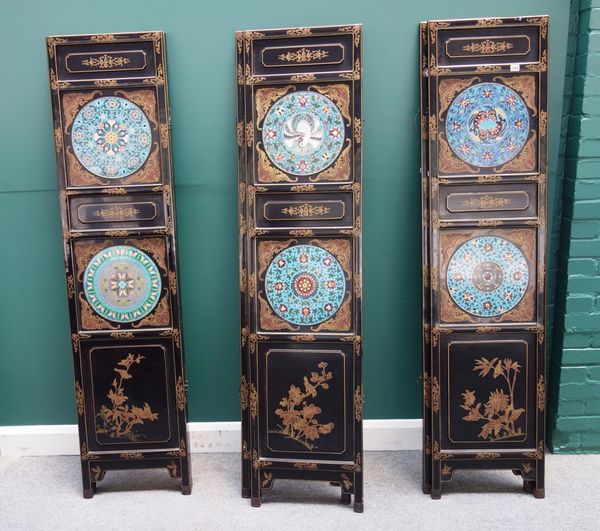 A 20th century Chinese black lacquer six fold draught screen, each section mounted with two circular enamel panels, 264cm wide x 184cm high.