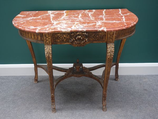 A late 19th century console table, the shaped marble top on a carved gilt base, with four cabriole supports united by shaped stretcher, 100cm wide.