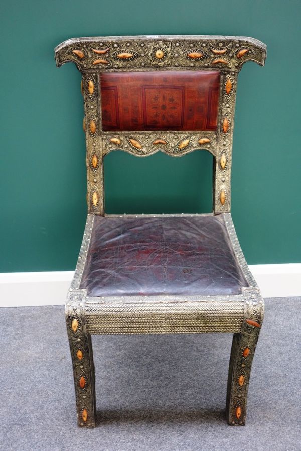 A 19th century silver and bone inlaid embossed leather upholstered side chair, of Islamic influence, on sabre supports.