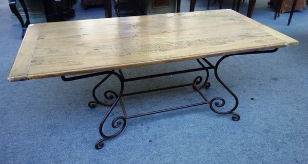 A rectangular oak dining table, on four wrought iron scroll supports united by stretcher, 91cm x 180cm.