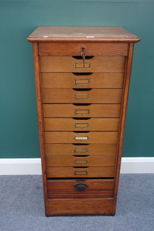 A 20th century oak filing cabinet, the tambour front enclosing nine drawers, 50cm wide.