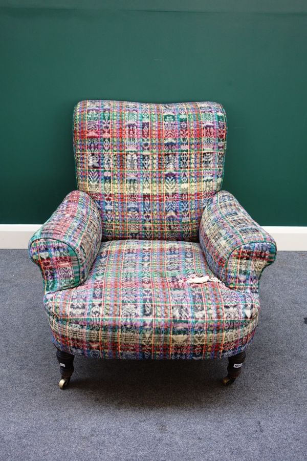 A Howard style Victorian deep seated easy armchair, on turned mahogany front supports.