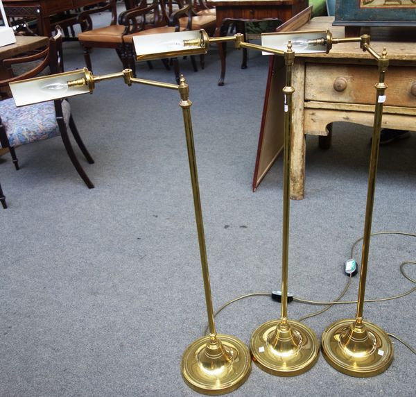 A set of three 20th century floor standing brass anglepoise reading lamps. (3)