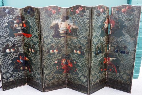 A 19th century arch top brass studded six fold draft screen, painted with fruiting vines and birds of paradise, within a trellis background, 273cm wid