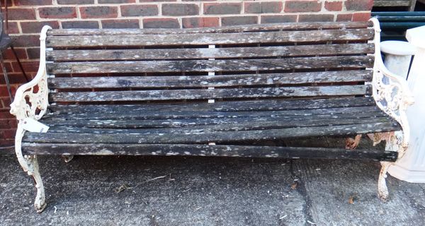 An early 20th century white painted cast iron bench with beast head finials, on scroll feet, 189cm wide.