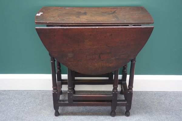 A late 17th century oak drop flap table on turned supports 70cm wide.