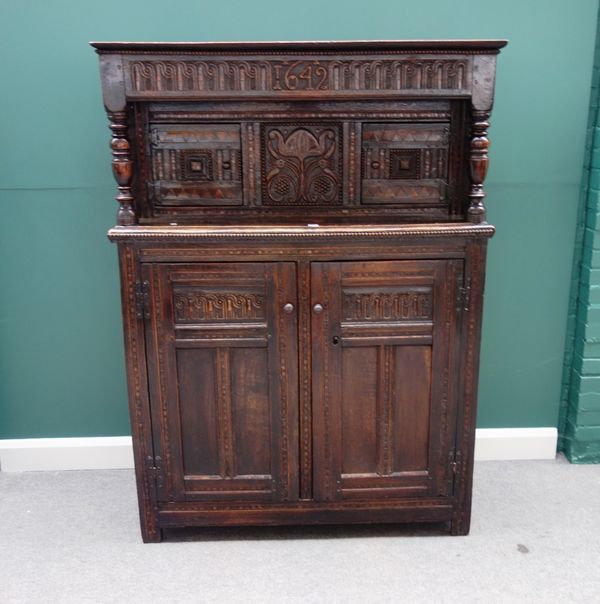 A 17th century and later oak court cupboard, with carved and geometric decoration about the four cupboards, 126cm wide x 172cm high.