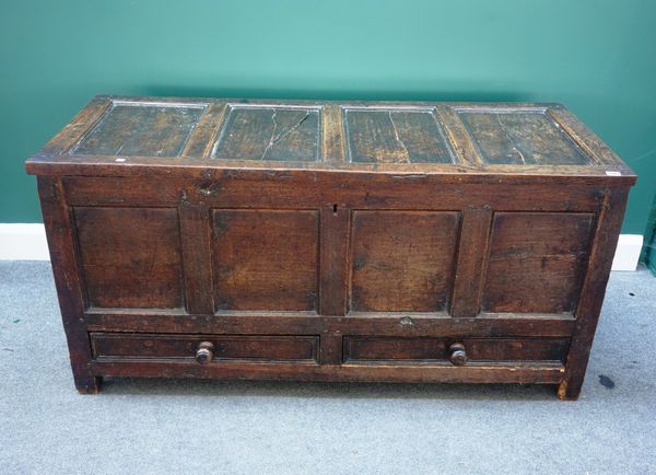 A George III oak mule chest, with triple panel lid and front, over a pair of drawers, 143cm wide.