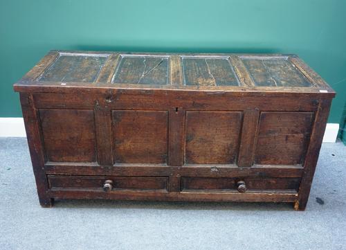 A George III oak mule chest, with triple panel lid and front, over a pair of drawers, 143cm wide.