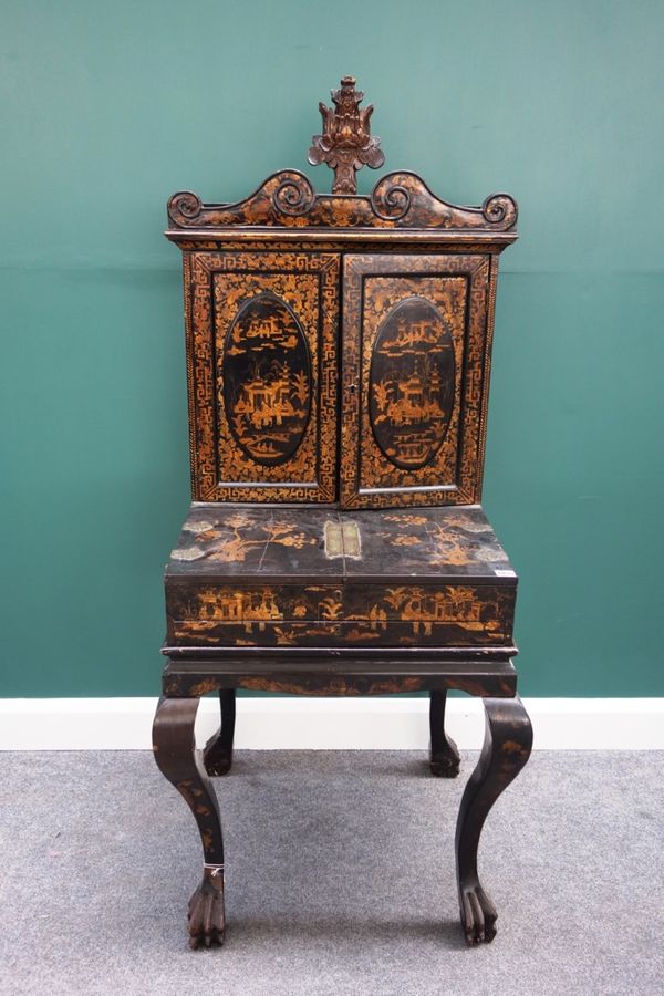 An early 19th century and later Chinese black lacquer chinoiserie decorated cabinet on stand, the two pairs of doors revealing a fitted interior, on f