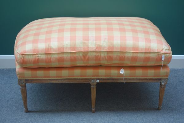 A Louis XVI style footstool, the rectangular top with single rounded end, on tapering fluted supports, 116cm wide.