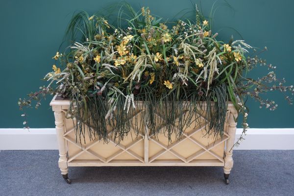 A Regency style cream painted jardiniere, with diamond slatted sides, on turned supports, 94cm wide.