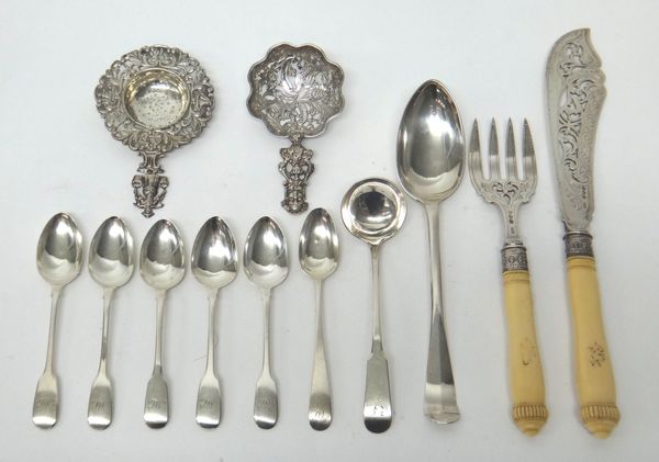 A decorative sugar sifting spoon, the cast and pierced handle having a masked finial, import mark London 1891, a straining spoon, decorated in the Dut