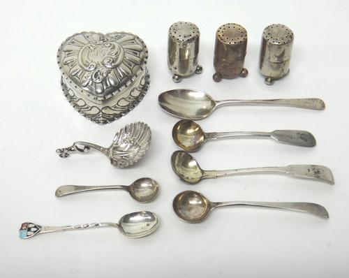 Silver, comprising; a Victorian heart shaped hinge lidded trinket box, with embossed decoration, Birmingham 1894, three pepperettes, each raised on th