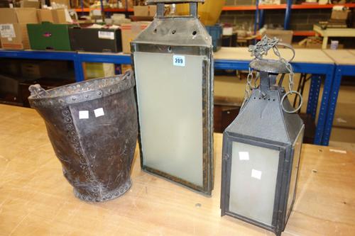 An 18th century leather fire bucket and two 20th century lanterns, (3).