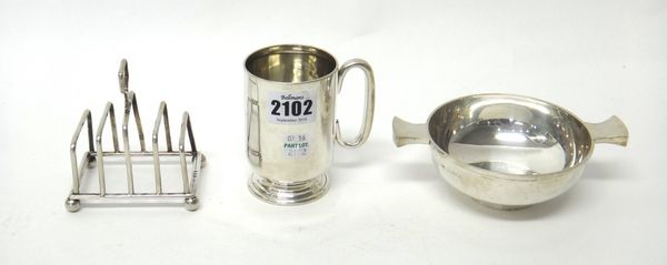 Silver, comprising; a christening mug having a C shaped handle, Birmingham 1903, a twin handled quaich London 1936 and a small five bar toastrack, rai