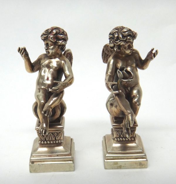 A pair of European models of seated cherubs, each raised on a square base, detailed 800, probably Italian, 10.5cm high (one flower lacking).