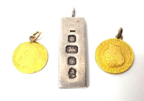 A George III sovereign 1817 mounted as a pendant, a George III half spade Guinea 1797 mounted as a pendant and a silver rectangular ingot pendant, Lon