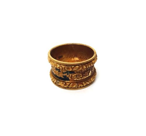 An 18ct gold and formerly black enamelled mourning band ring, detailed to the exterior 'In Memory Of' between floral decorated bands and milled rims,